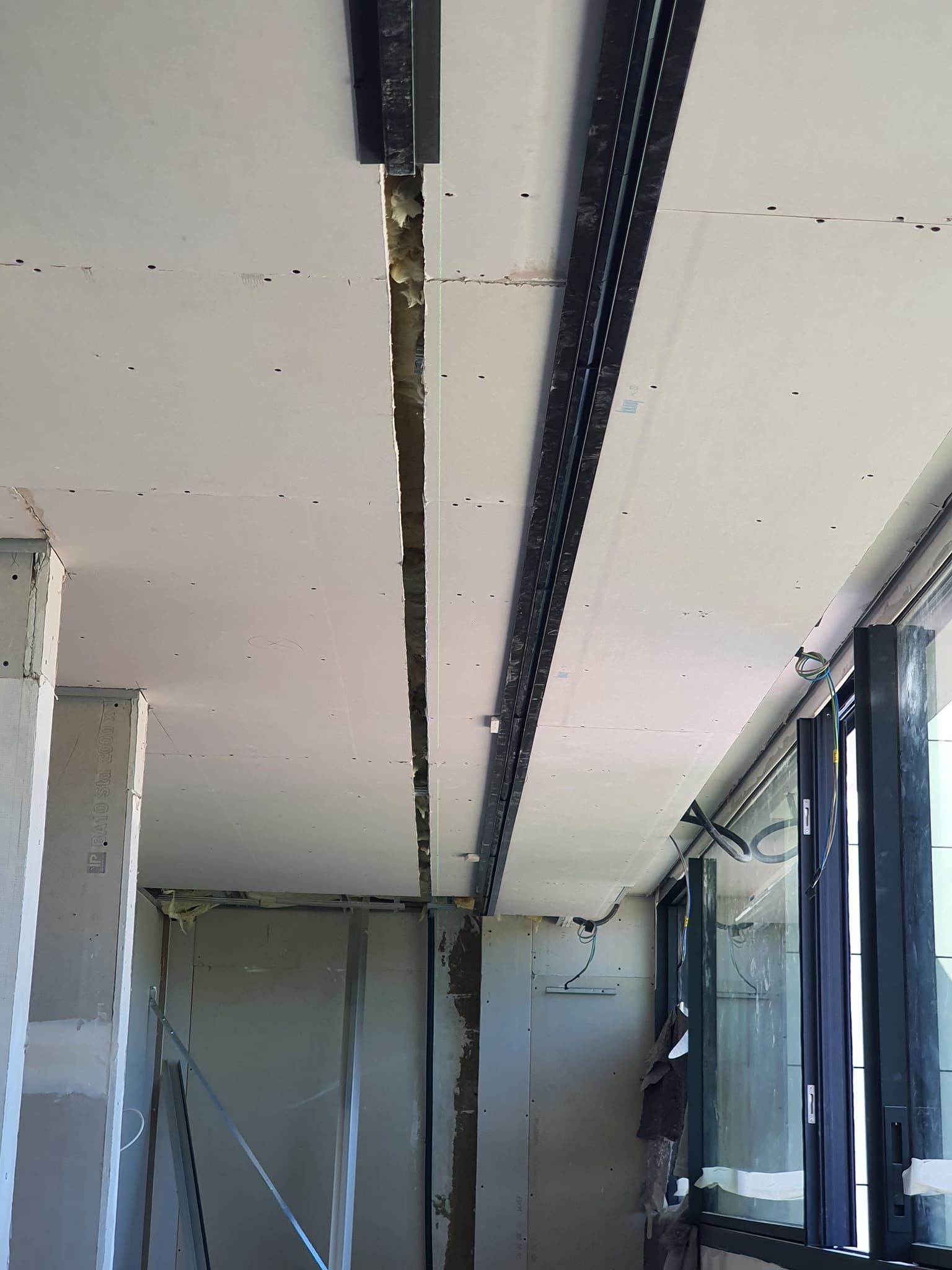 Techo con drywall y canales metálicos de color negro; construcción interior.