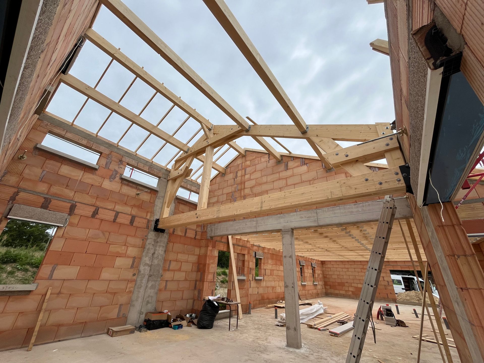 Chevrons et poutres en bois dans un grenier, supportant la toiture.