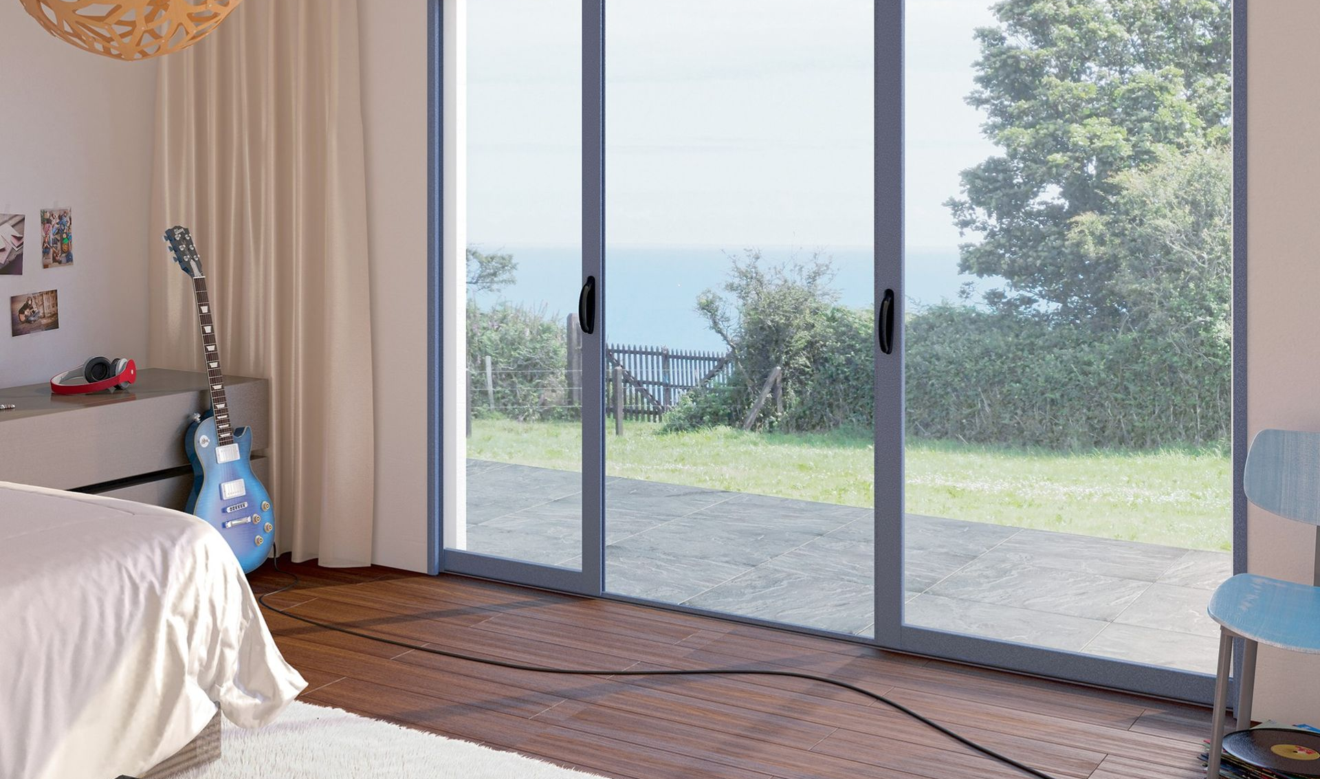 Chambre avec de grandes portes coulissantes en verre donnant sur un jardin ensoleillé et une vue sur l'océan.