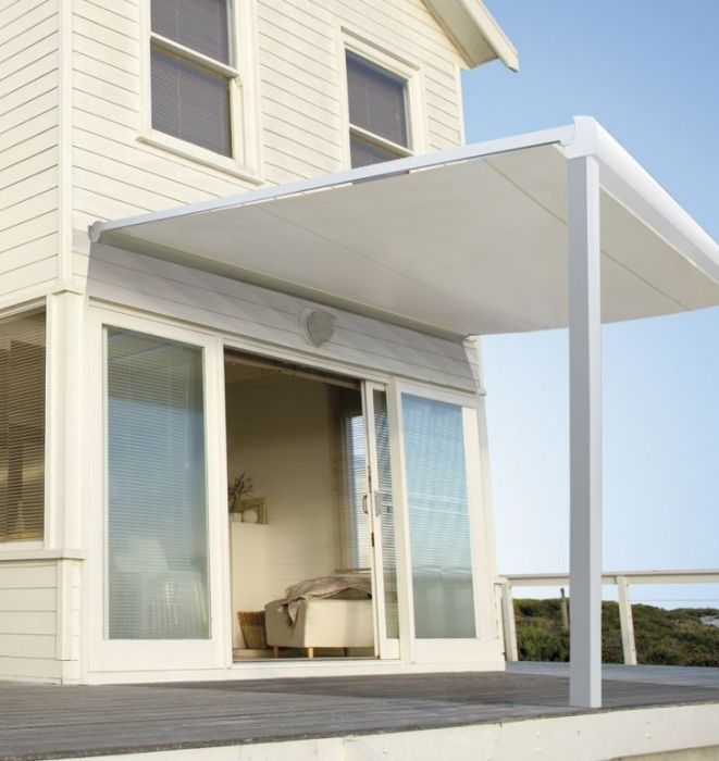 Patio de maison blanche moderne avec portes coulissantes en verre et terrasse couverte