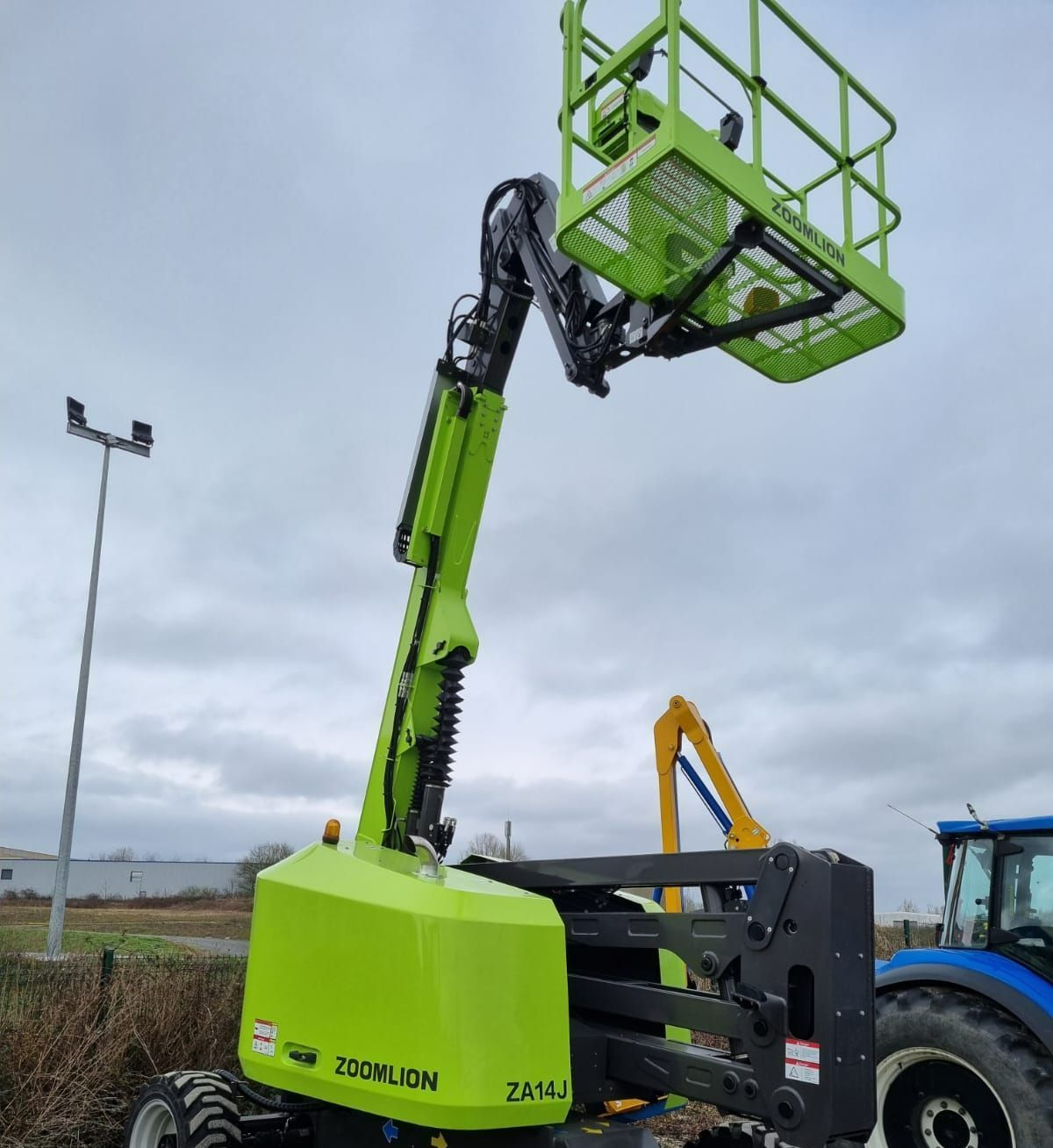 Nacelle verte à côté d'un tracteur bleu