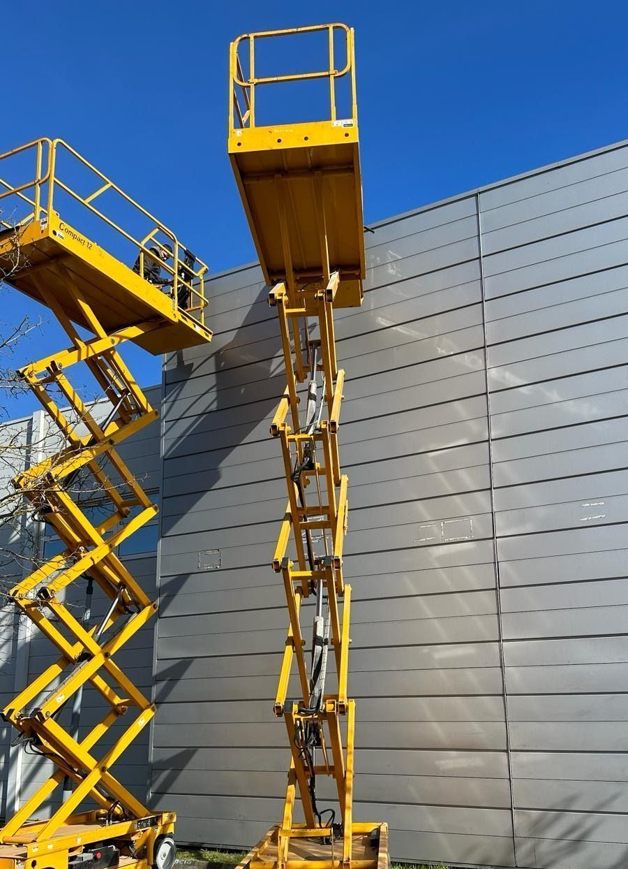 Deux nacelles ciseaux jaunes placées l'une à côté de l'autre