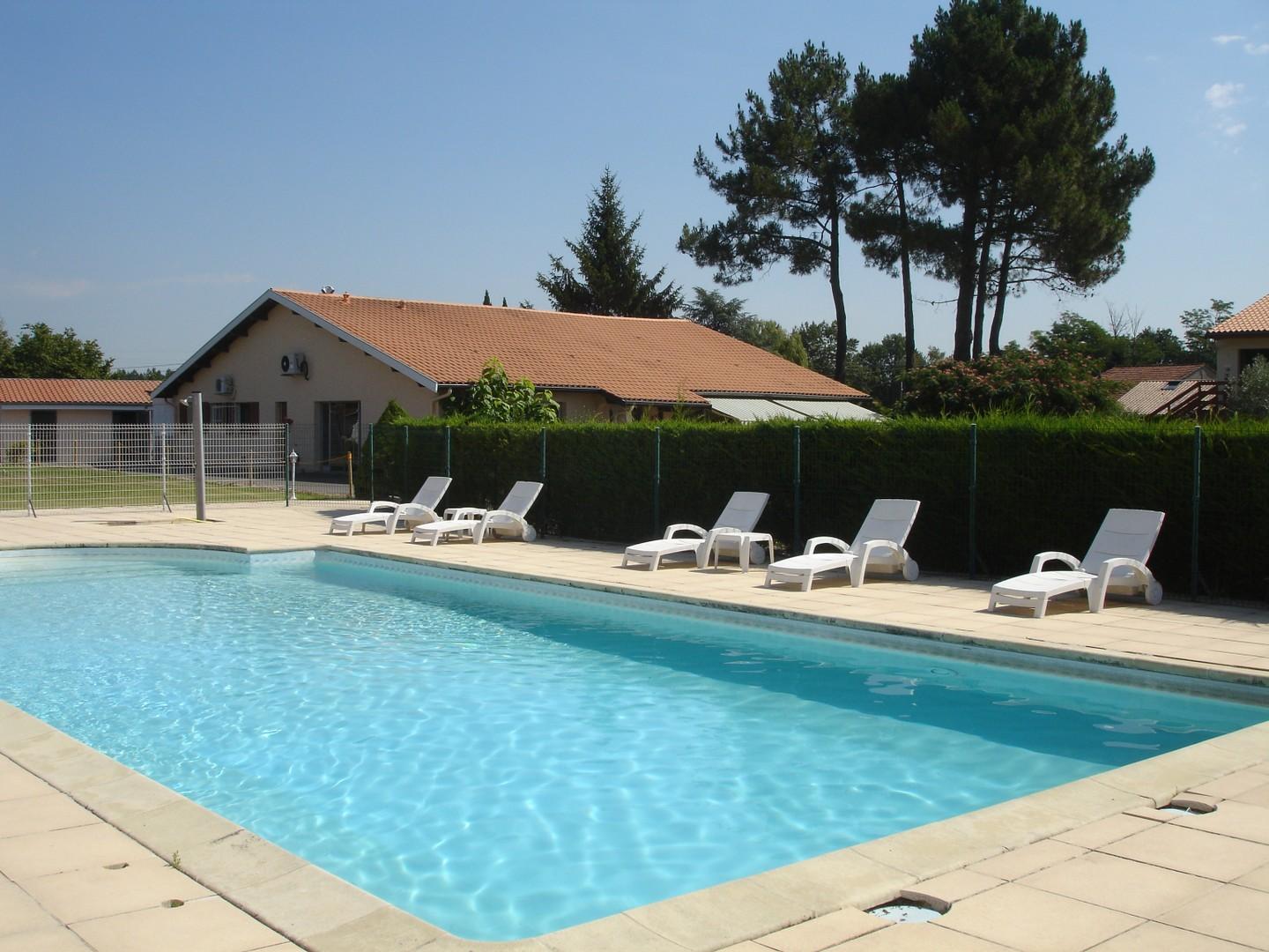 Piscine avec chaises longues