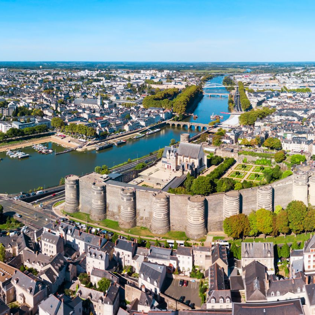 Vue aérienne d'une forteresse historique en bord de rivière et d'une vieille ville au bord d'un fleuve sinueux sous un ciel bleu clair