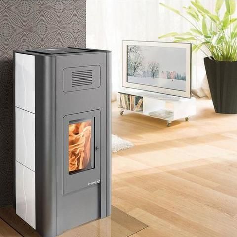 Un poêle à granulés gris moderne, avec un feu crépitant derrière une porte vitrée, dans un salon à côté d'un meuble TV.