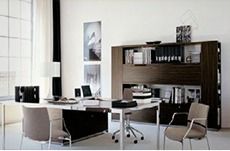 Oficina moderna con un escritorio grande, sillas y un armario de almacenamiento de madera oscura.