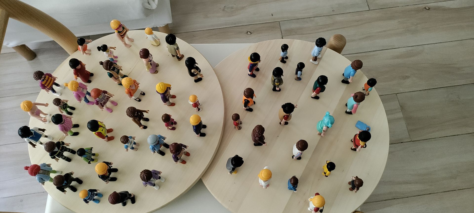 Un grupo de muñecas de madera están sentadas en un piso de madera.
