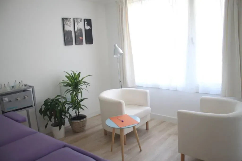 Una sala de estar con dos sillas y una mesa.