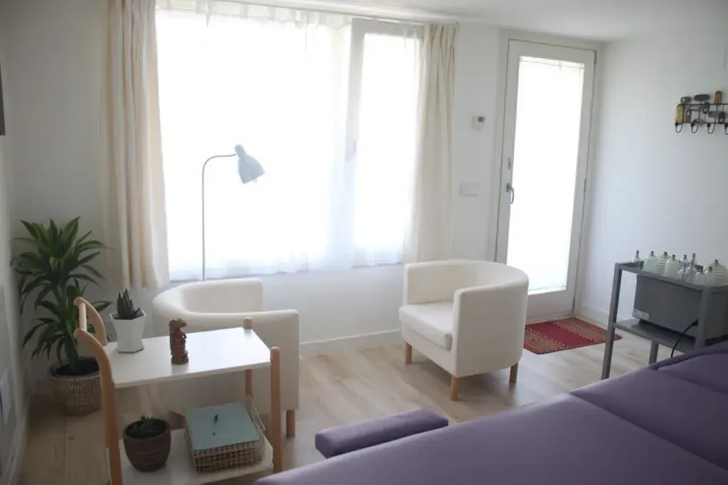 Una sala de estar con dos sillas y una mesa.