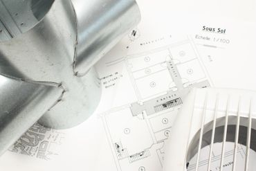 Plan architectural avec conduits métalliques argentés et ventilateur blanc sur la droite