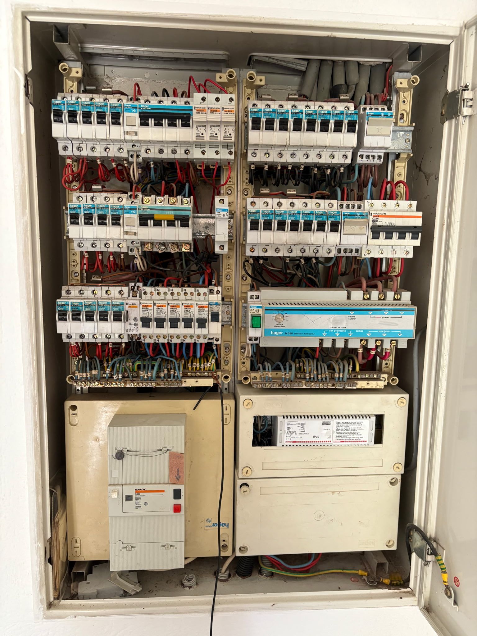 Tableau électrique avec rangées d'interrupteurs et câblage à l'intérieur d'une armoire murale
