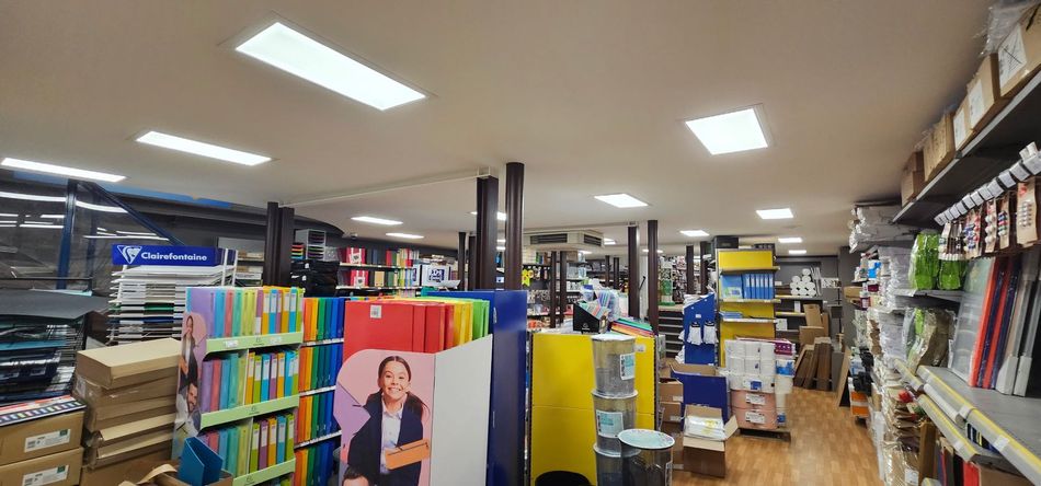 Allée de librairie avec des livres colorés, des étagères et des lumières vives au plafond