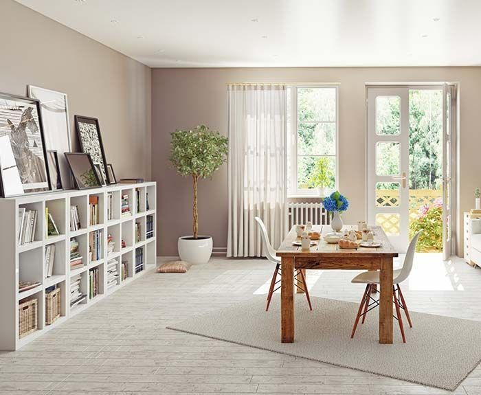 Una sala de estar con una mesa y sillas y una estantería.