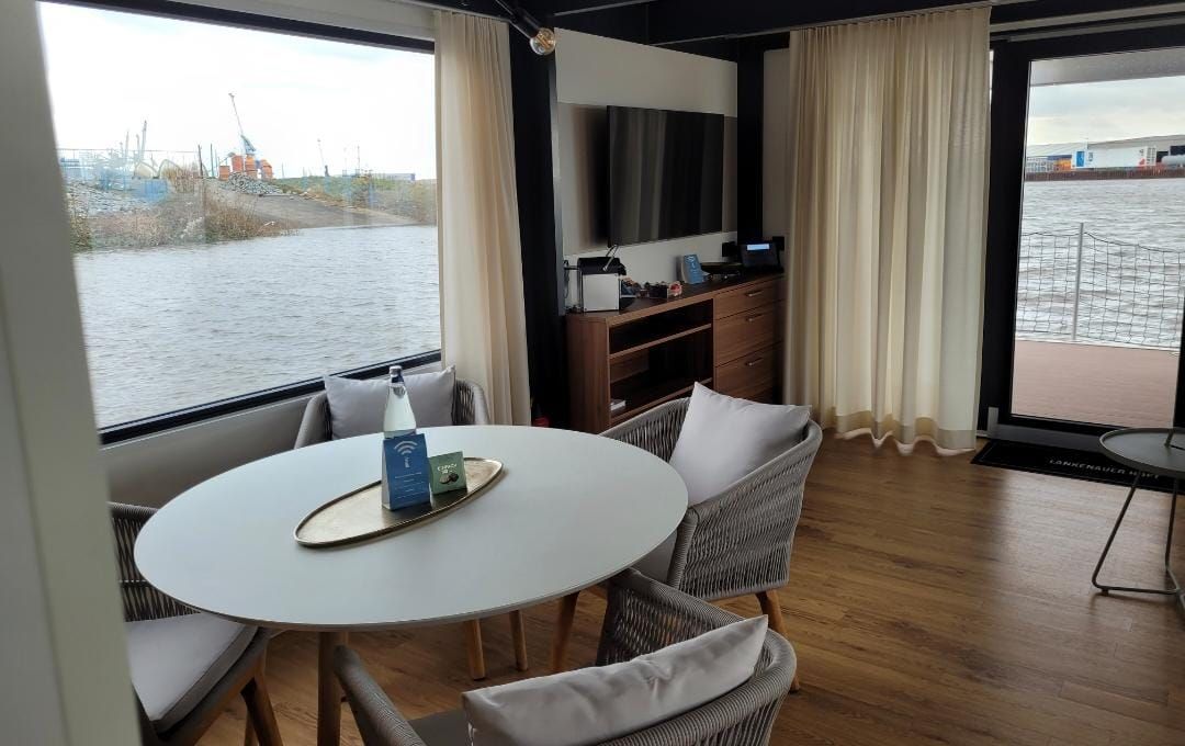 Im Zimmer mit Blick auf das Wasser gibt es einen Tisch und Stühle.