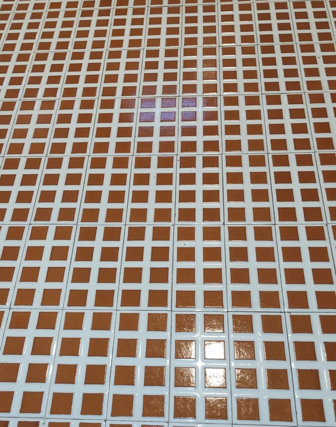Ein braun-weißer Fliesenboden mit Gittermuster