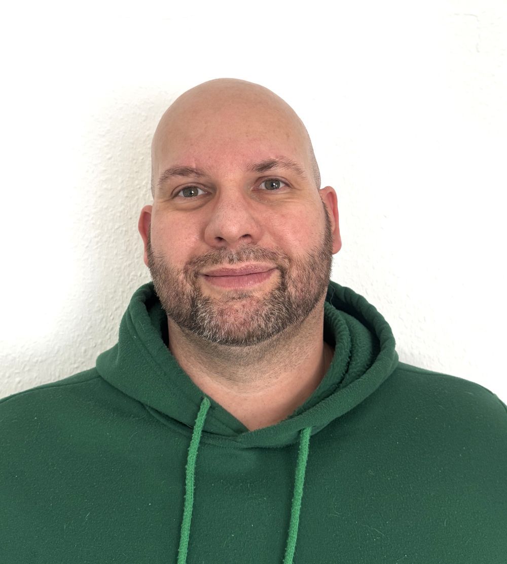 Eine Nahaufnahme einer Frau mit Brille und einer Tätowierung auf der Brust.