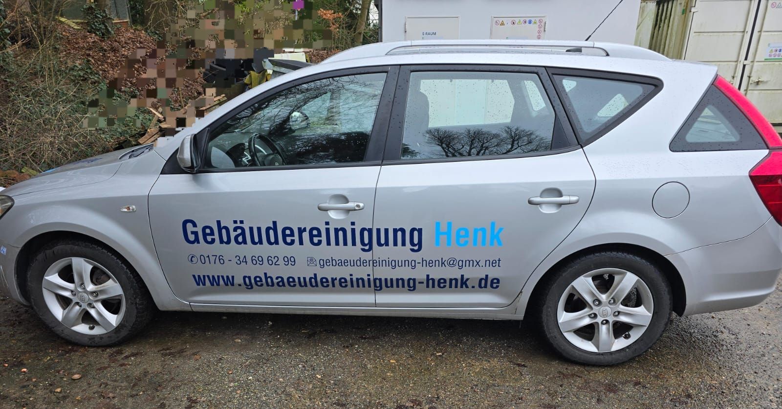Ein silbernes Auto mit dem Wort Henk auf der Seite