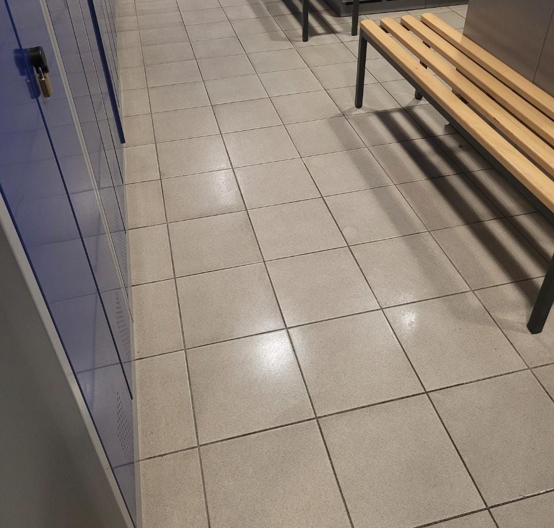 Ein gefliester Boden mit einer Holzbank in einem Umkleideraum