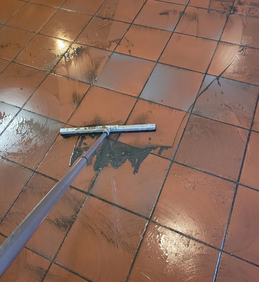 Ein Besen liegt auf einem gefliesten Boden