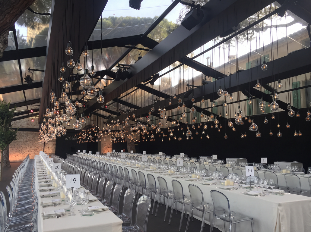 Élégante salle de banquet avec de longues tables nappées de blanc sous une tente transparente