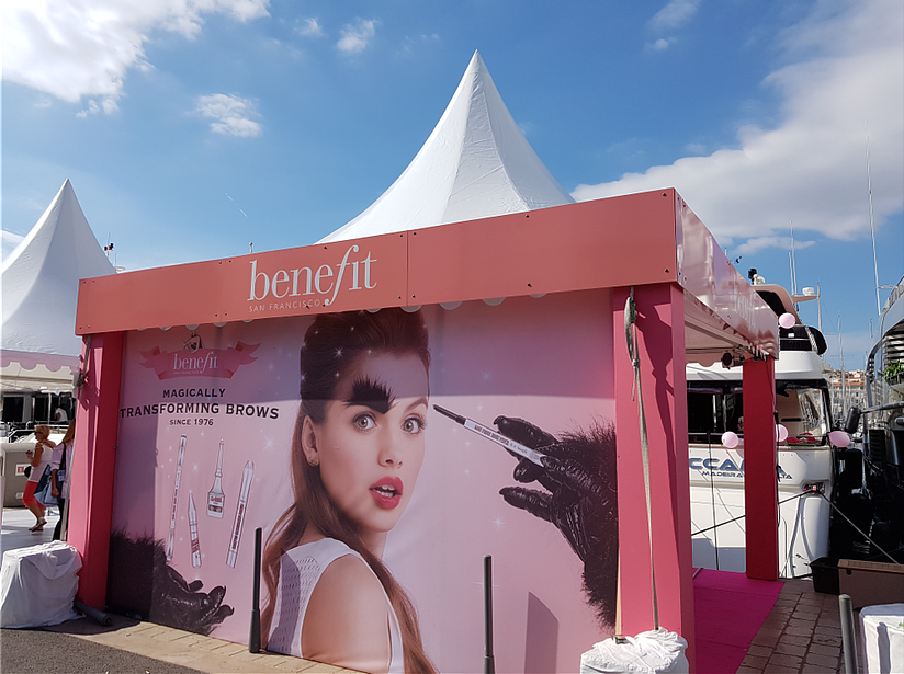 Stand rose de Benefit Cosmetics avec une grande affiche