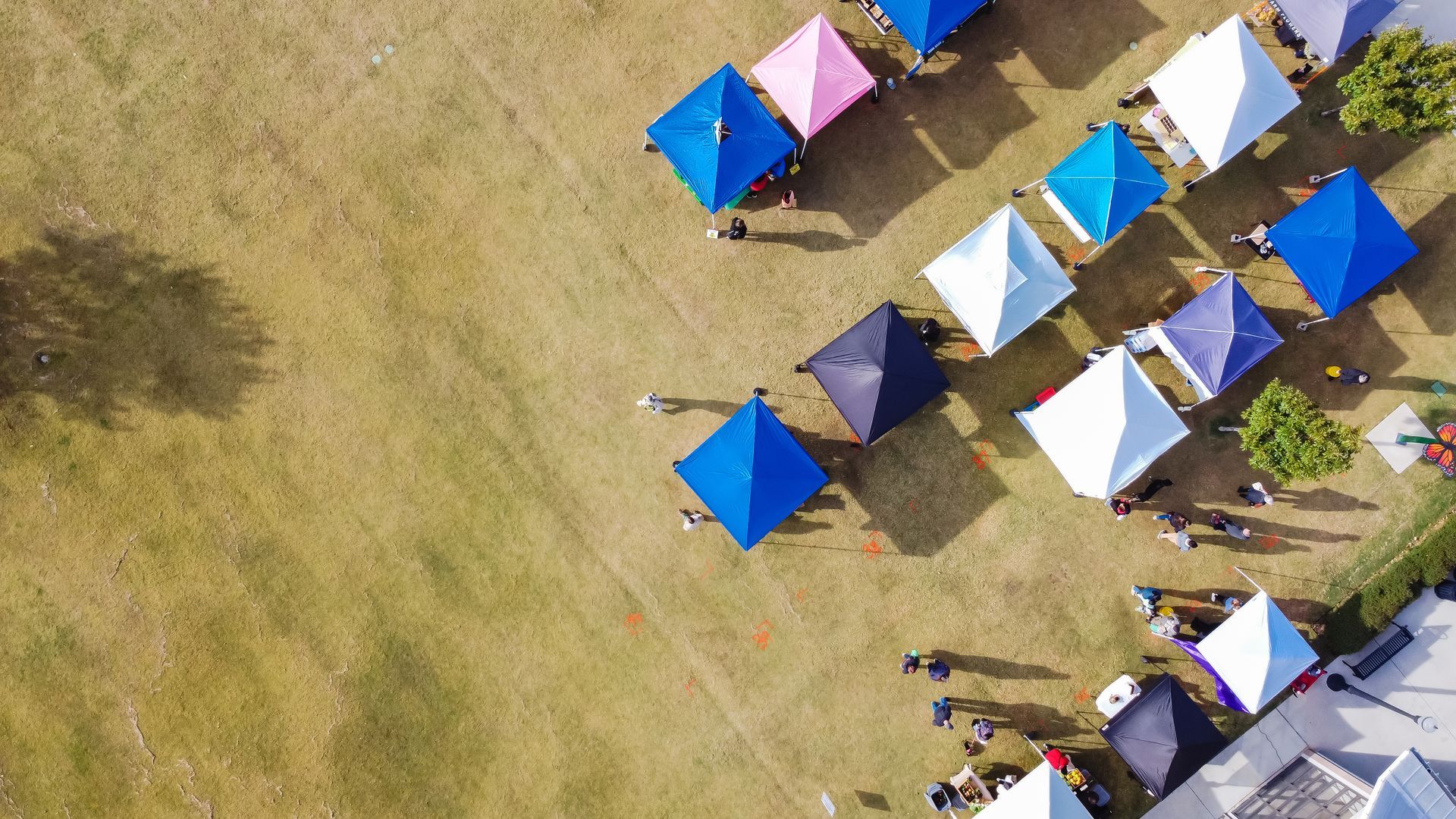Vue aérienne de tentes colorées disposées sur un terrain herbeux dans un camping en plein air