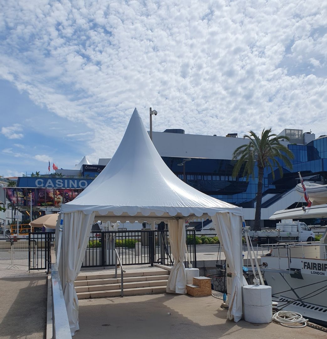 Une tente blanche à baldaquin près d'un port de plaisance