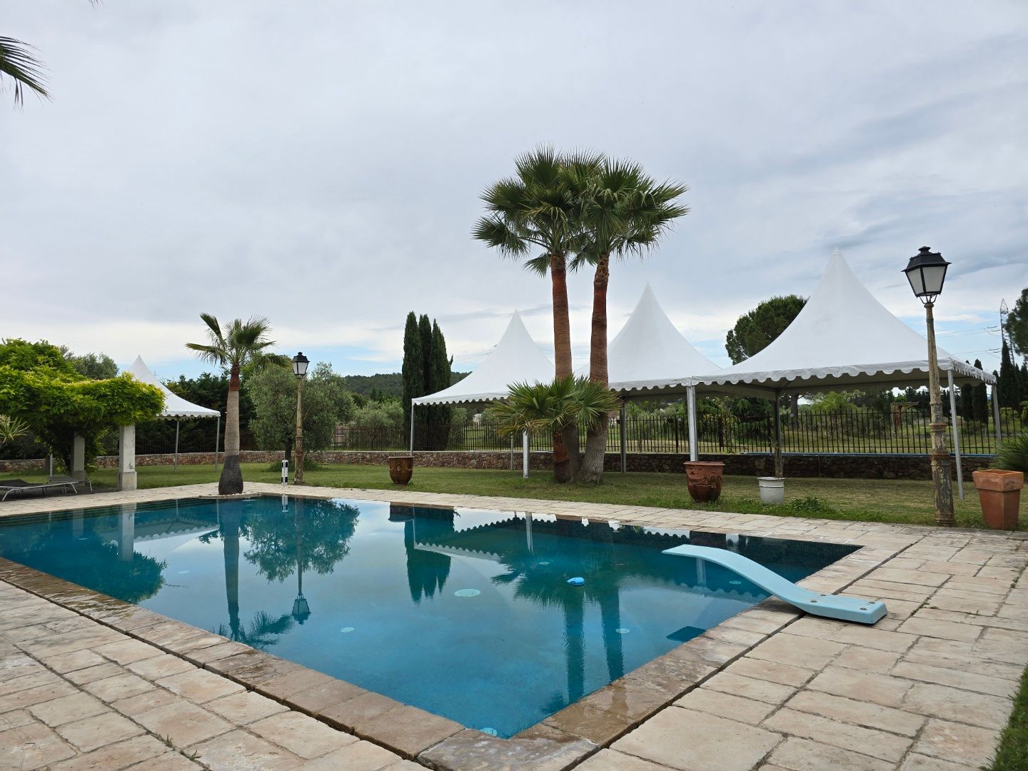 Chapiteaux devant une piscine dans le jardin d'un particulier