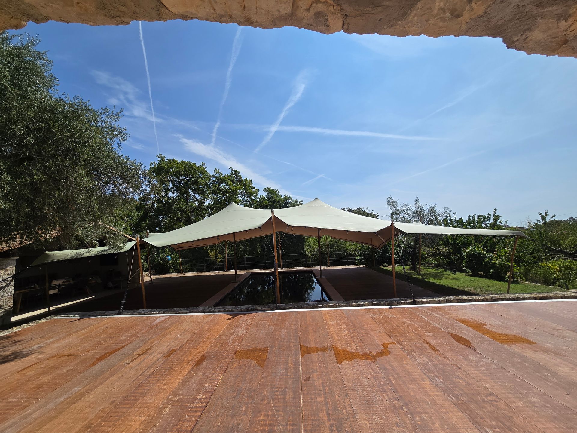 Terrasse en bois donnant sur un coin salon extérieur ombragé