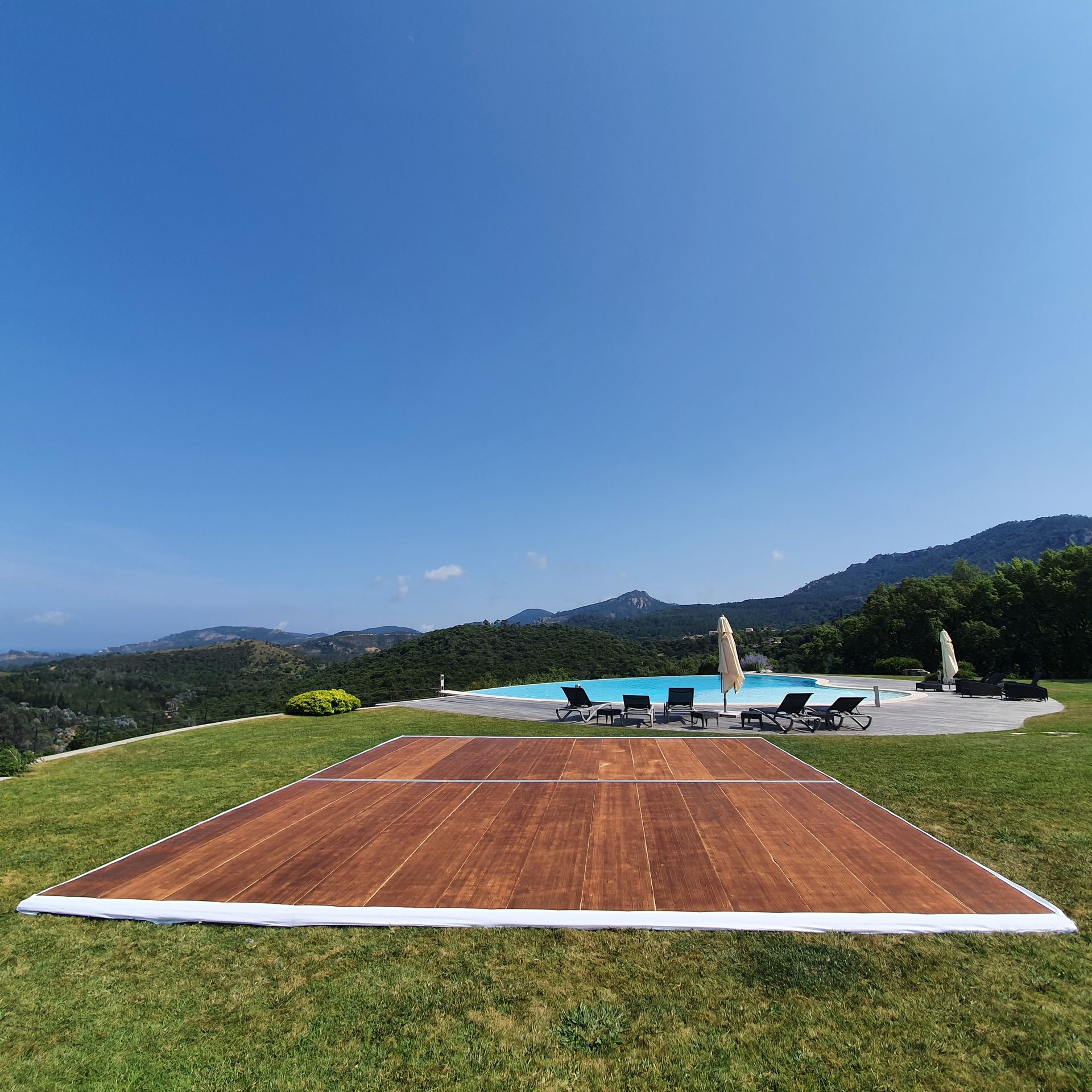 Piste de danse en bois au bord d'une piscine à débordement