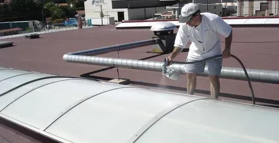 Professionnel appliquant de la laque solaire sur une voûte en polycarbonate