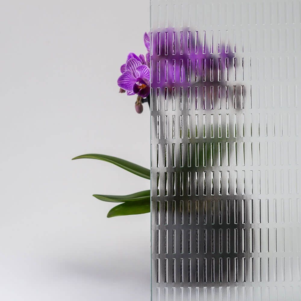 Lila Orchidee hinter gemustertem Glas.