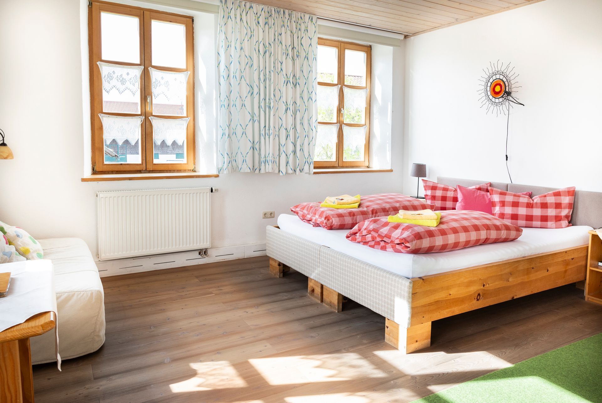 Restauranteinrichtung mit Holztischen und -stühlen, hellen Wänden und Hängelampen. Sonnenlicht strömt durch die Fenster.