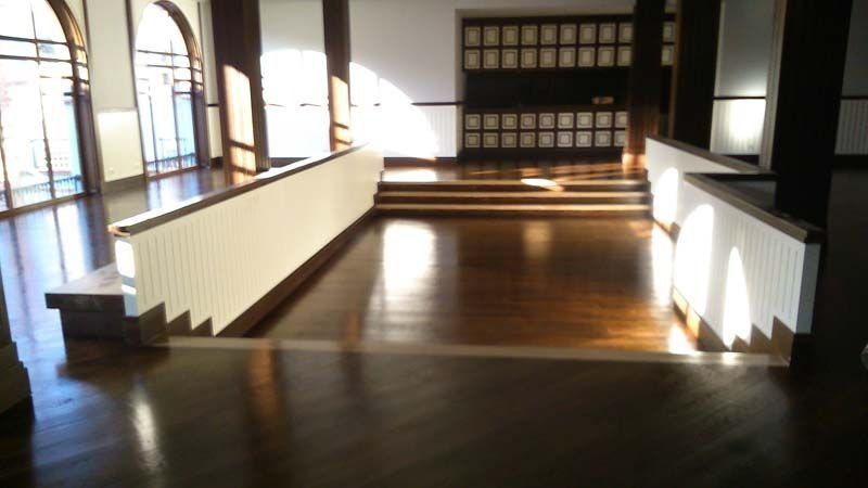 Una habitación vacía con suelo de madera y escaleras.