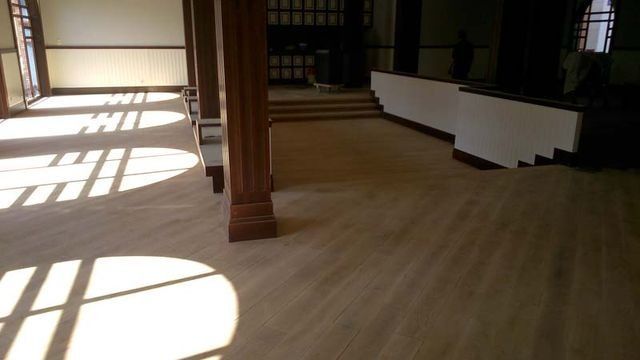 Una gran habitación vacía con suelo de madera y escaleras.