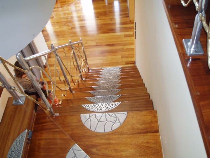Una escalera de madera con barandilla de acero inoxidable