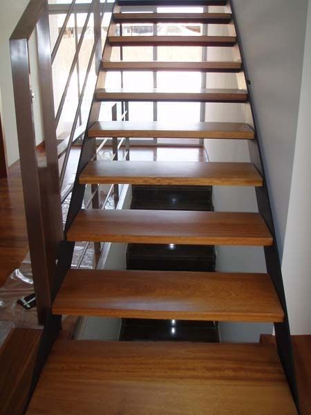 Una escalera con escalones de madera y barandilla de metal