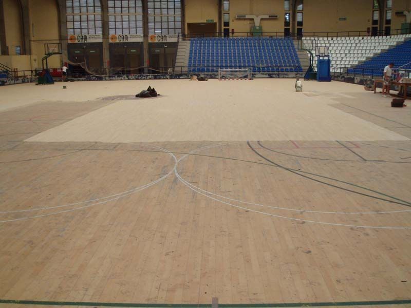 Una cancha de baloncesto vacía con gradas al fondo