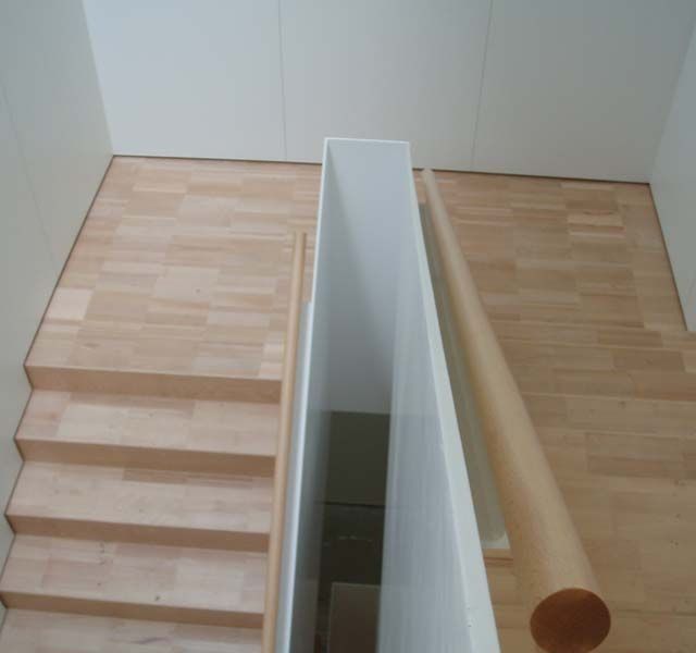 Una escalera con escalones de madera y barandilla blanca.