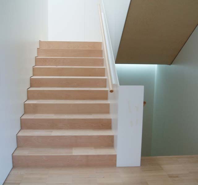 Un conjunto de escaleras de madera con barandilla blanca.