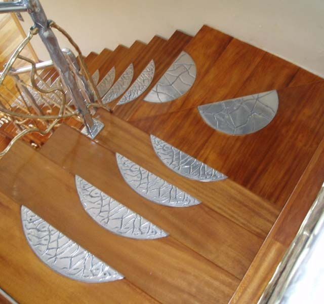 Una escalera de madera con escalones de metal y una barandilla de metal.