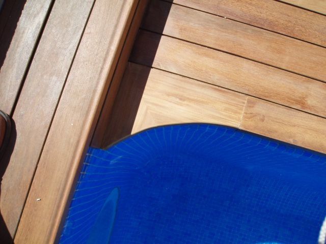 Una tabla de surf azul está sobre una plataforma de madera.