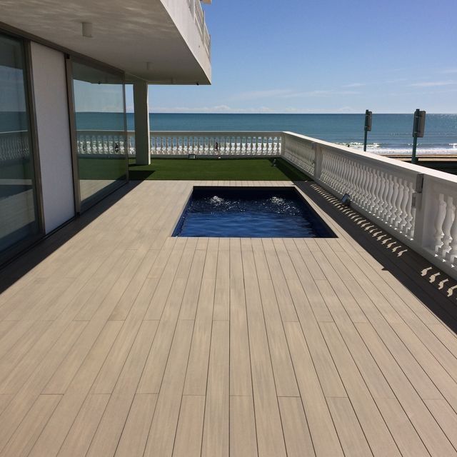 Una terraza con piscina y vista al mar.