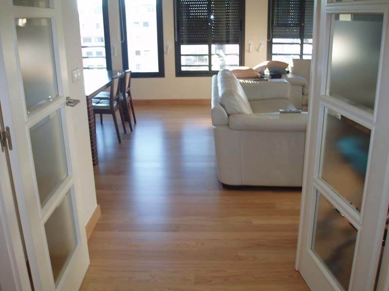 Una sala de estar con un sofá blanco y una mesa.