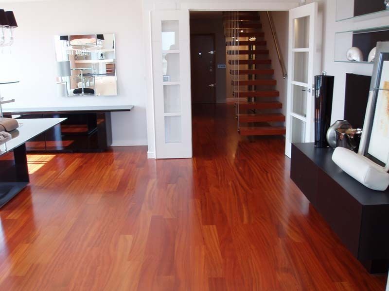 Una sala de estar con pisos de madera y una escalera.