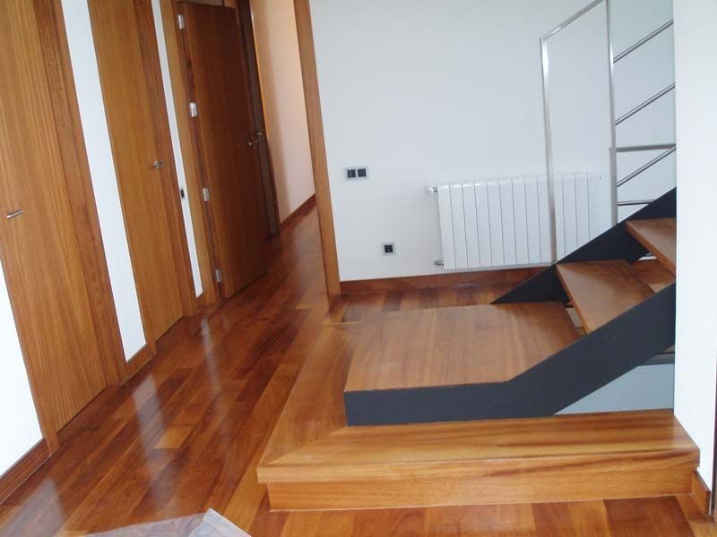 Un pasillo con suelo de madera y una escalera de caracol.