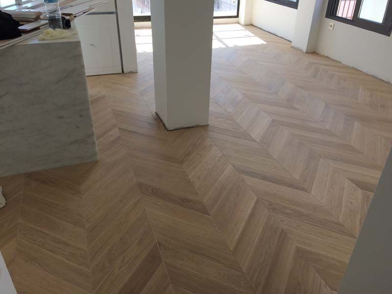 Un suelo de madera con diseño de espiga en una habitación.