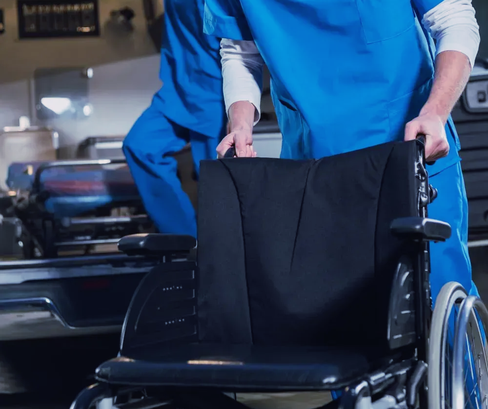 Des ambulanciers avec un fauteuil roulant