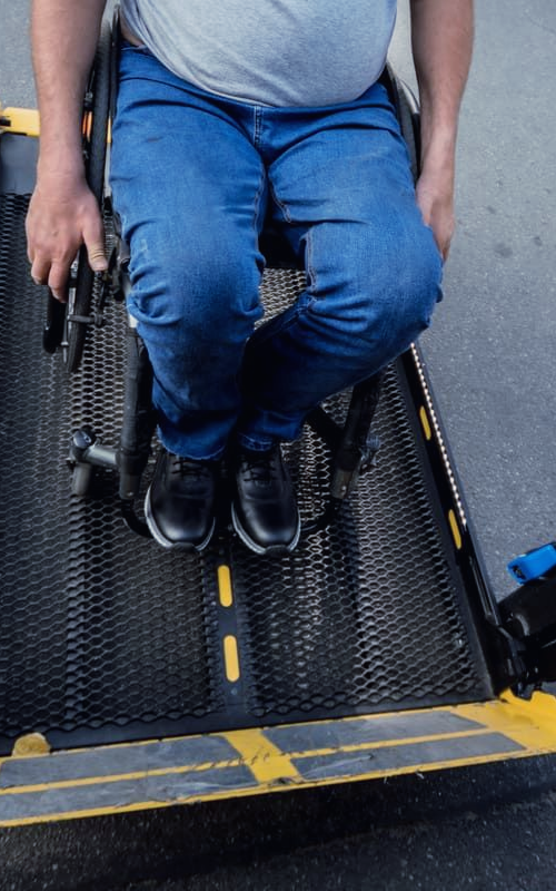 Personne à mobilité réduite en fauteuil roulant utilisant un véhicule de TPMR