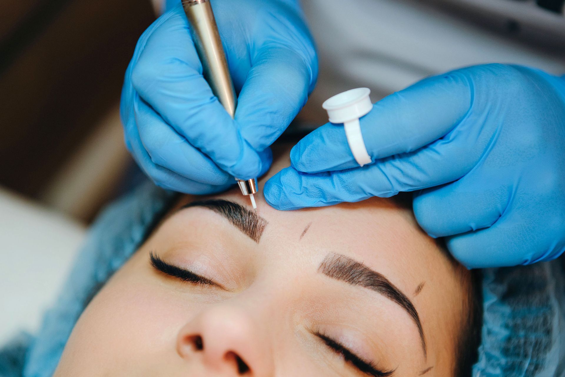 Eine Frau lässt sich Permanent Make-up für die Augenbrauen machen.